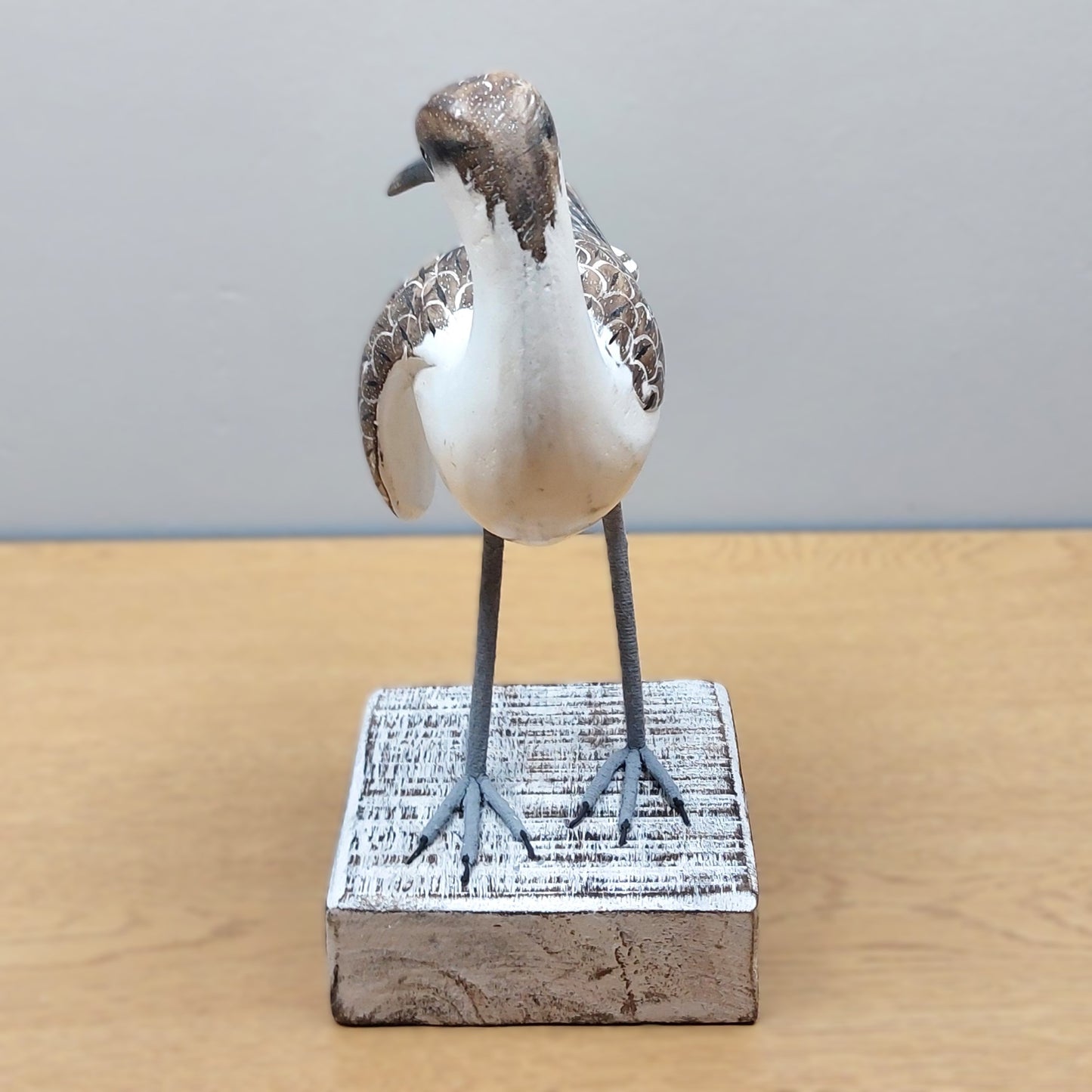 Hand carved and painted in Bali decorative Godwit bird figurine on a rectangular wooden whitewashed base with a gray background