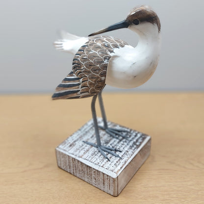 Decorative painted Brown and White Godwit bird figurine on a wooden base with a plain background