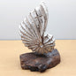 Decorative hand painted and carved White wooden shell sculpture on a wooden driftwood base against a plain background