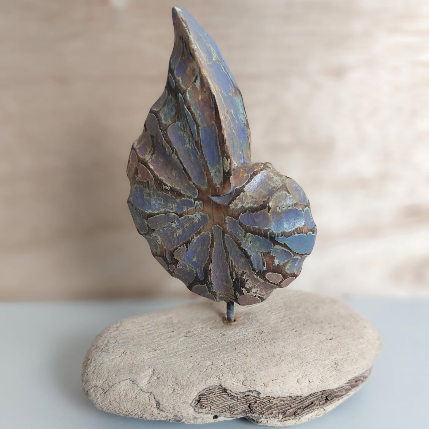 Decorative handmade and painted wooden shell made in Bali figurine on a wooden base with a neutral background