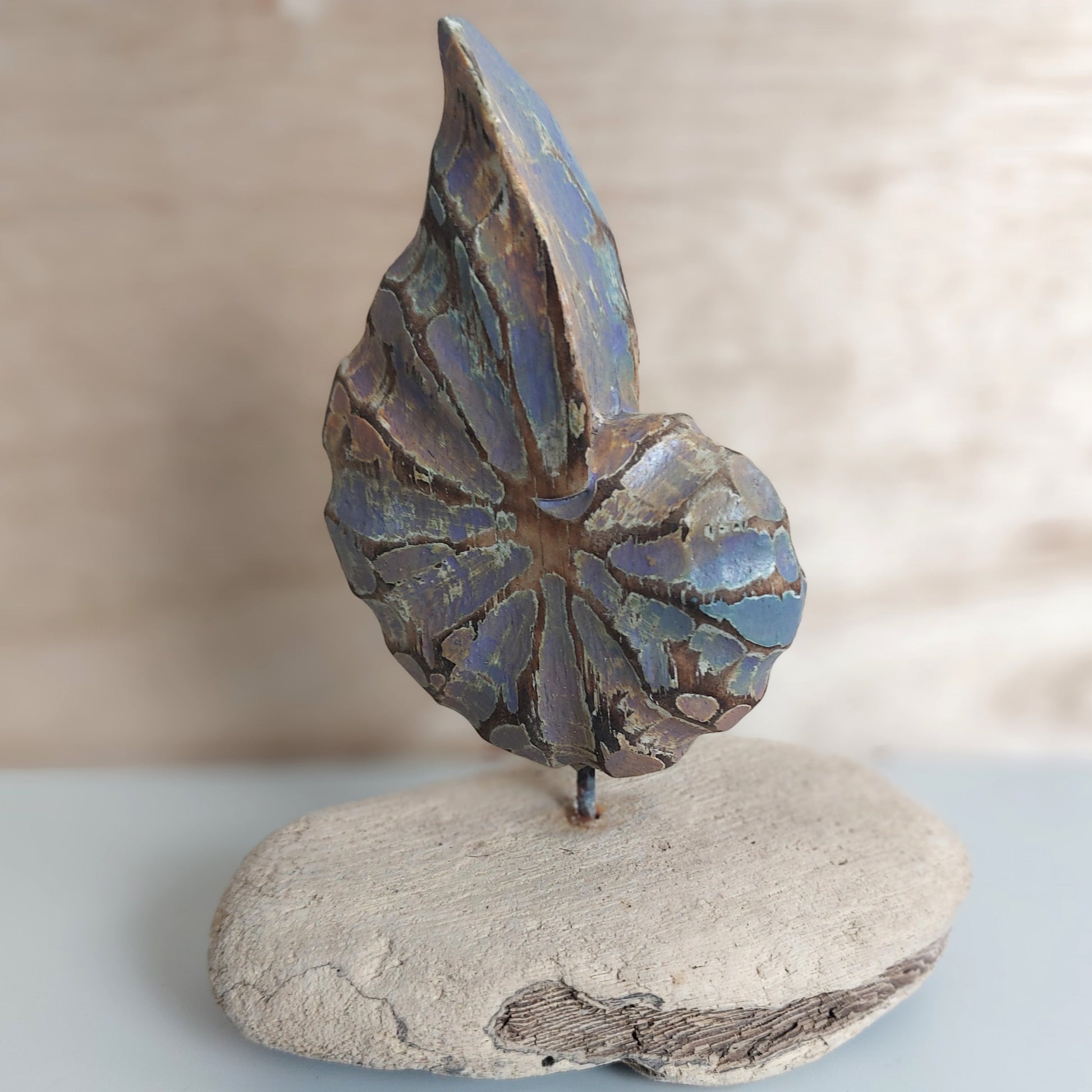 Decorative handmade and painted wooden shell made in Bali figurine on a wooden base with a neutral background
