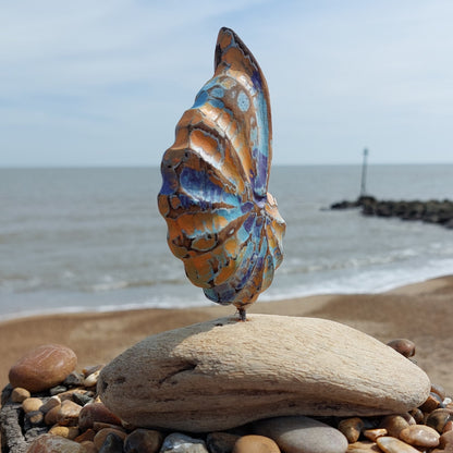Decorative shell sculpture on a rock with ocean and sky in the background