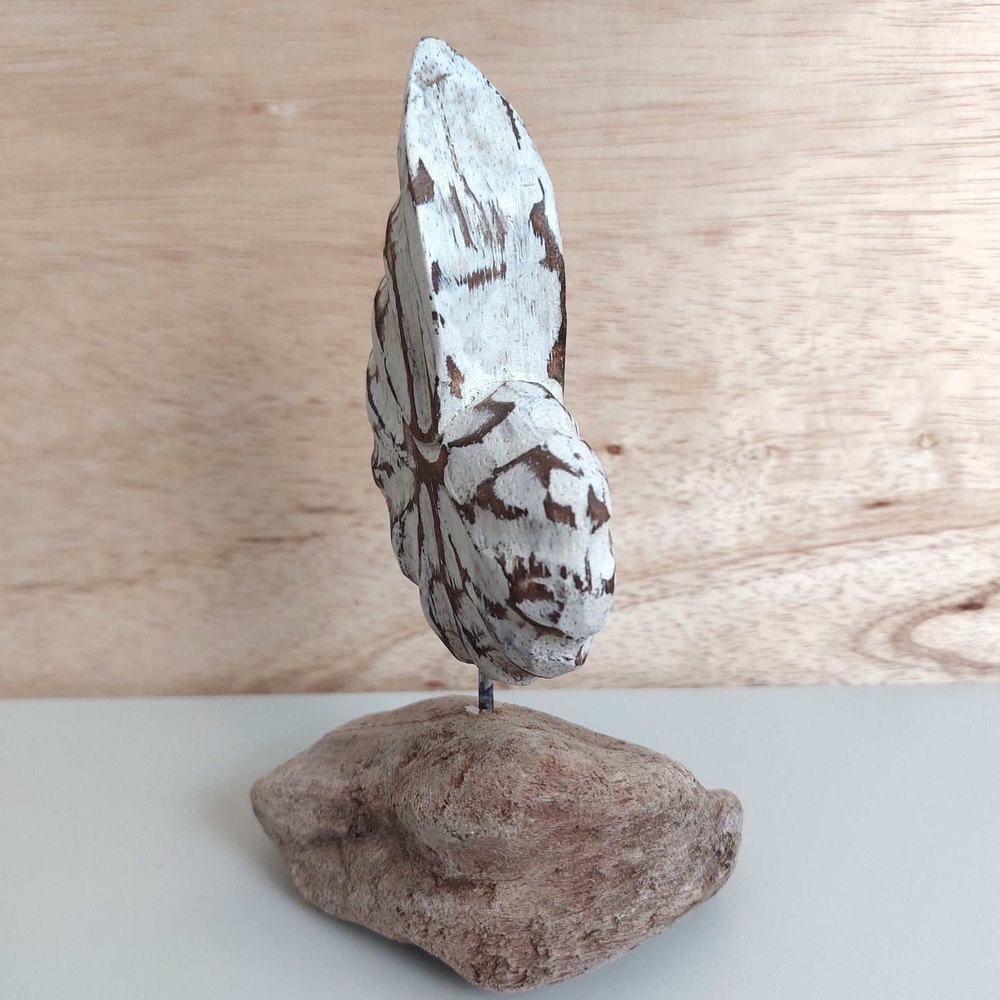 Decorative hand carved and painted wooden shell sculpture on a wooden surface