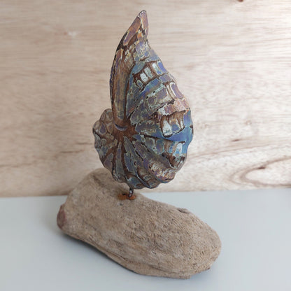 Decorative handmade and painted wooden shell on a wooden base against a wooden background