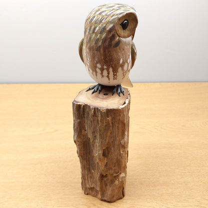 Ornate Wooden owl figurine on a wooden base against a plain background