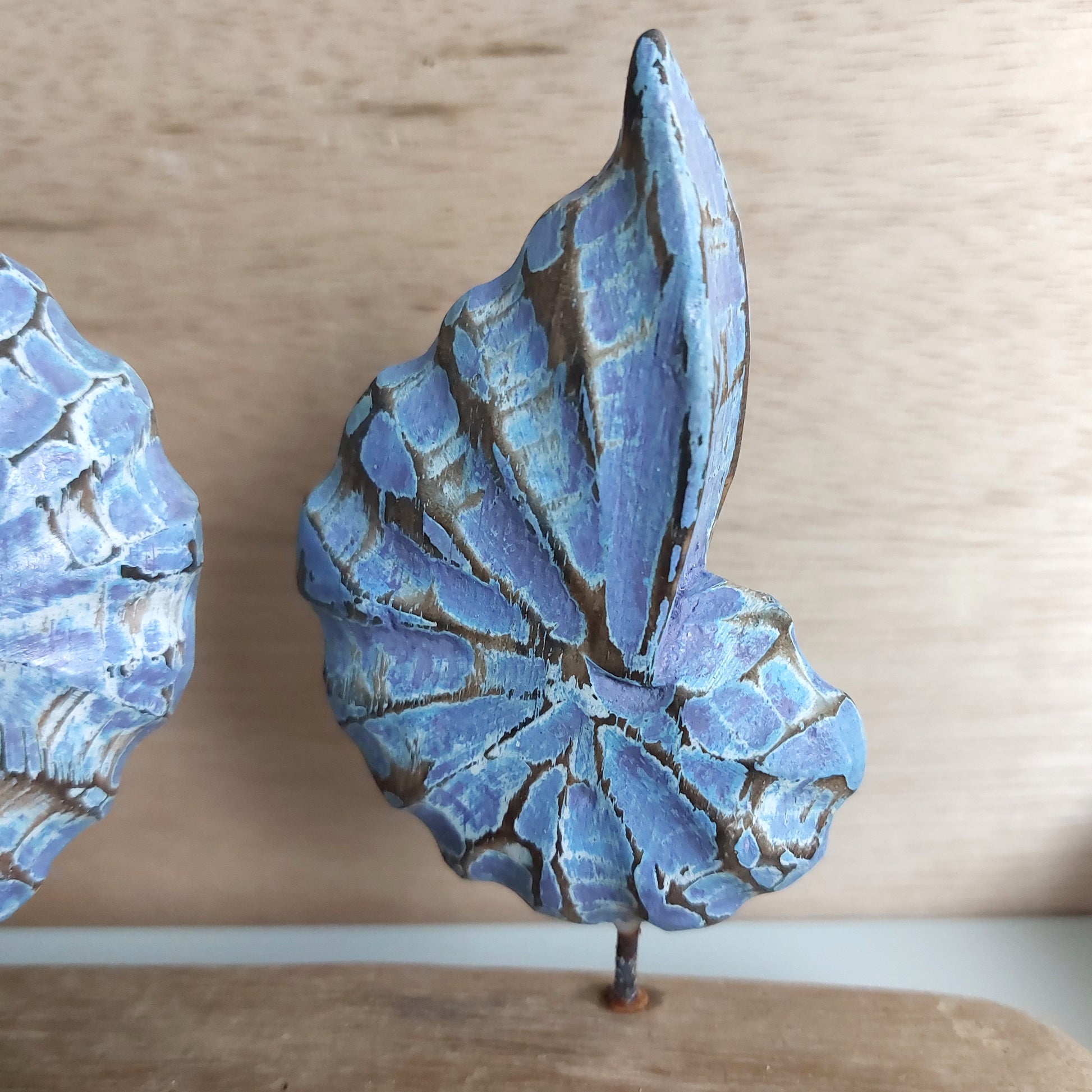 Blue and brown hand made and painted wooden shell on a wooden surface