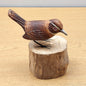 Wooden handmade carved Wren bird figurine on a wooden log base against a beige background