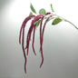 Purple flower artificial amaranthus branch with green leaves on a light gray background